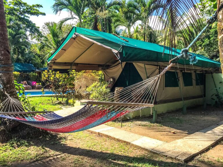 Ruime tent met hangmat onder palmbomen in costa rica