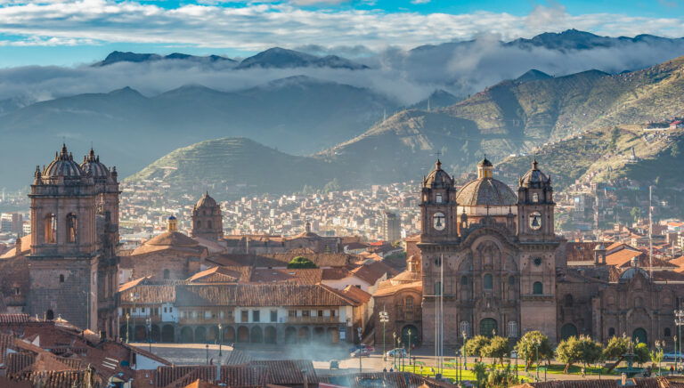 uitzicht op de stad cusco met de kathedraal en een bergachtig landschap op de achtergrond