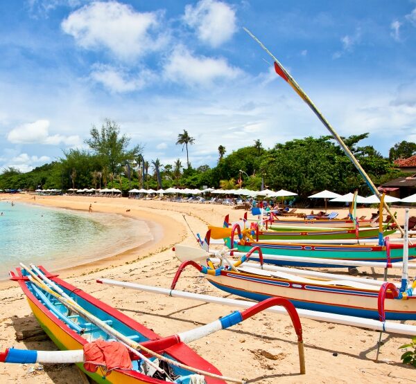Kleurrijke Balinese jukung vissersboten op het goudgele zand van Sanur Beach