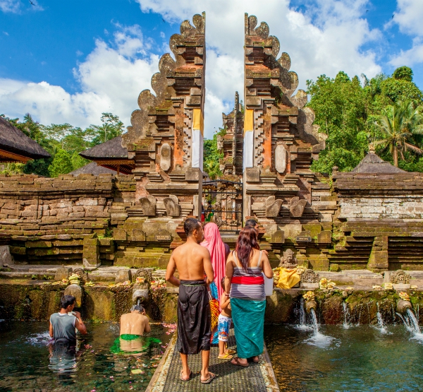 Mensen ondergaan een traditioneel Melukat reinigingsritueel in de hindoeïstische watertempel Pura Tirta Empul op Bali