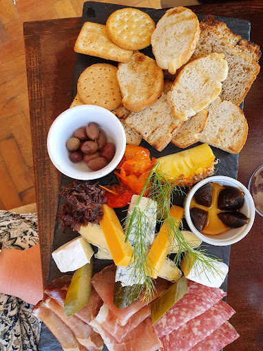 Borrelplank met broodjes, crackers, vleeswaren, kazen en olijven