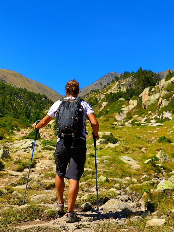 Man hikend in de pyreneeën van Spanje met wandelstokken