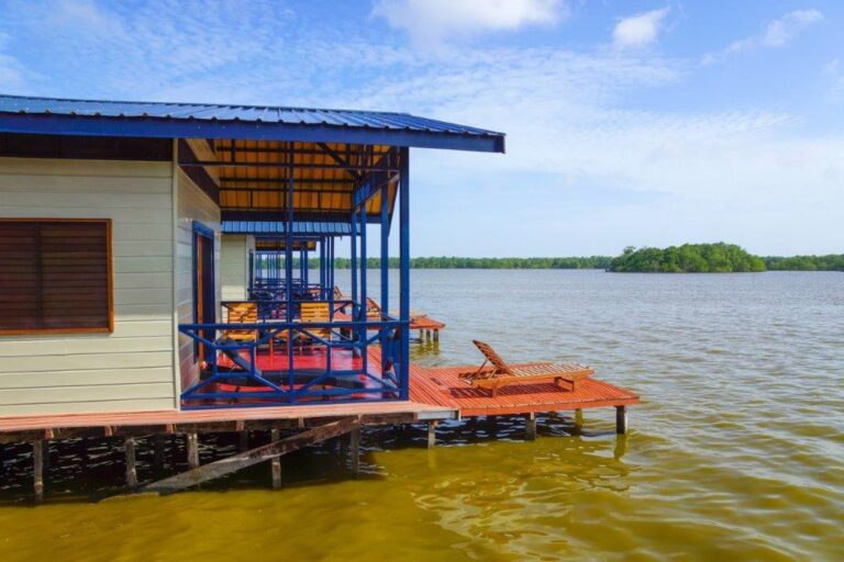 lodge met houten veranda met uitzicht over het meer in Suriname