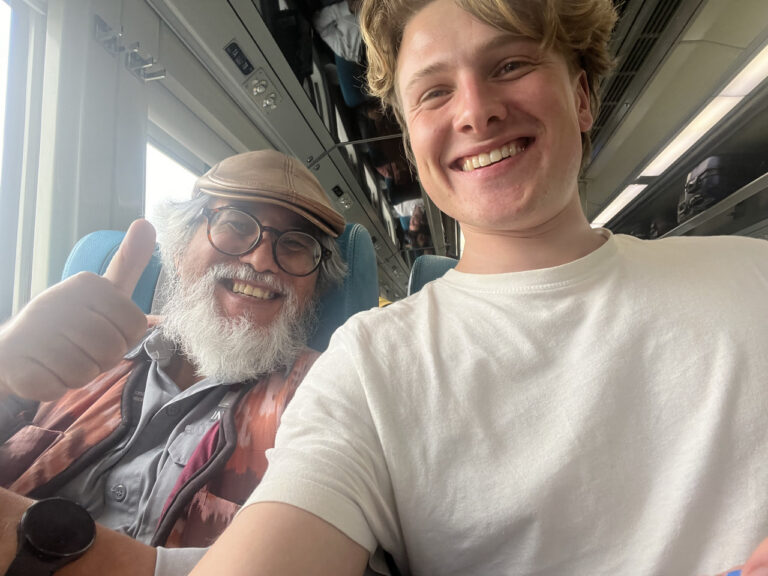 reiziger maakt selfie foto met local in de trein op Java