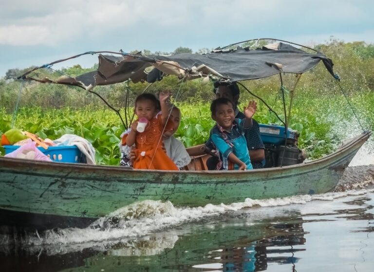 kinderen zwaaien naar voorbijgangers vanuit een bootje op het tempe lake