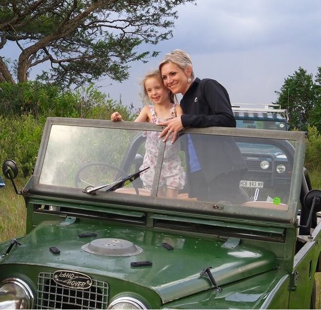 een moeder en een dochter kijken vanuit een jeep naar de savanne