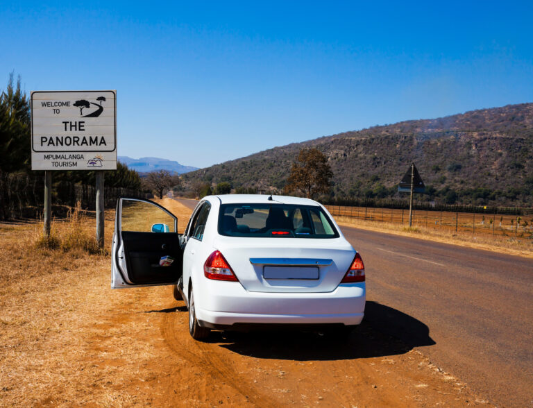 witte huurauto langs de weg in zuid-afrika