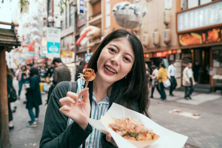 vrouw eet japans streetfood op straat