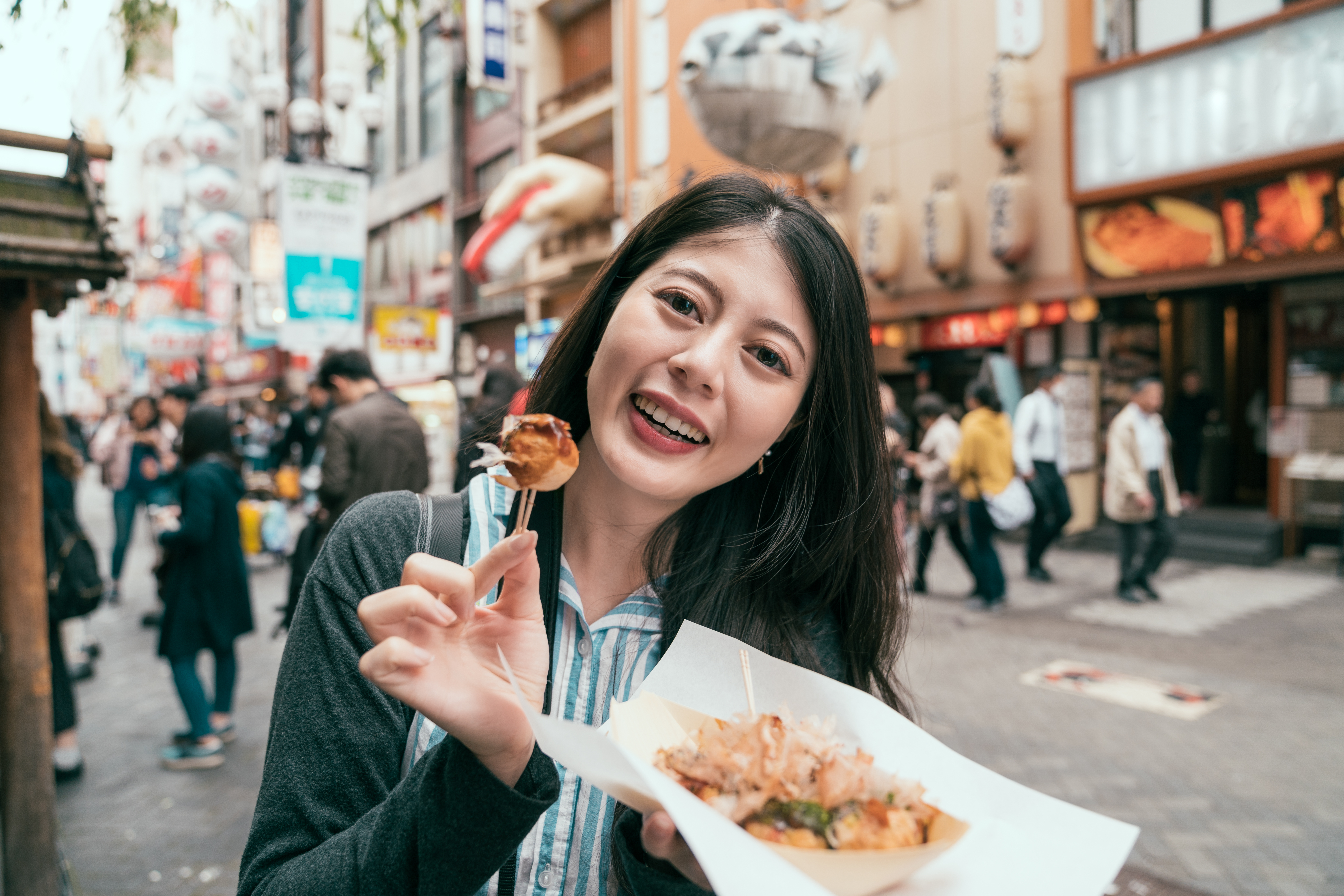 vrouw eet japans streetfood op straat