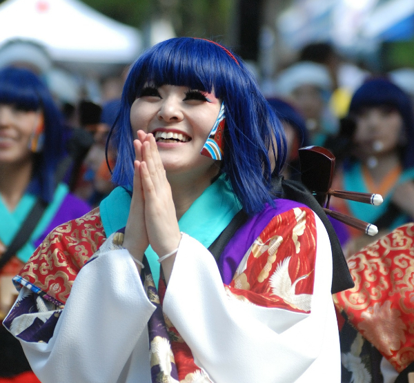 Japanse vrouw in kleurrijke traditionele kleding maakt gebaar van dankbaarheid