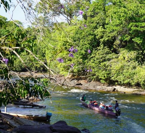 Groepje mensen in een korjaalboot op de Suriname rivier bij het Anaula Nature Resort