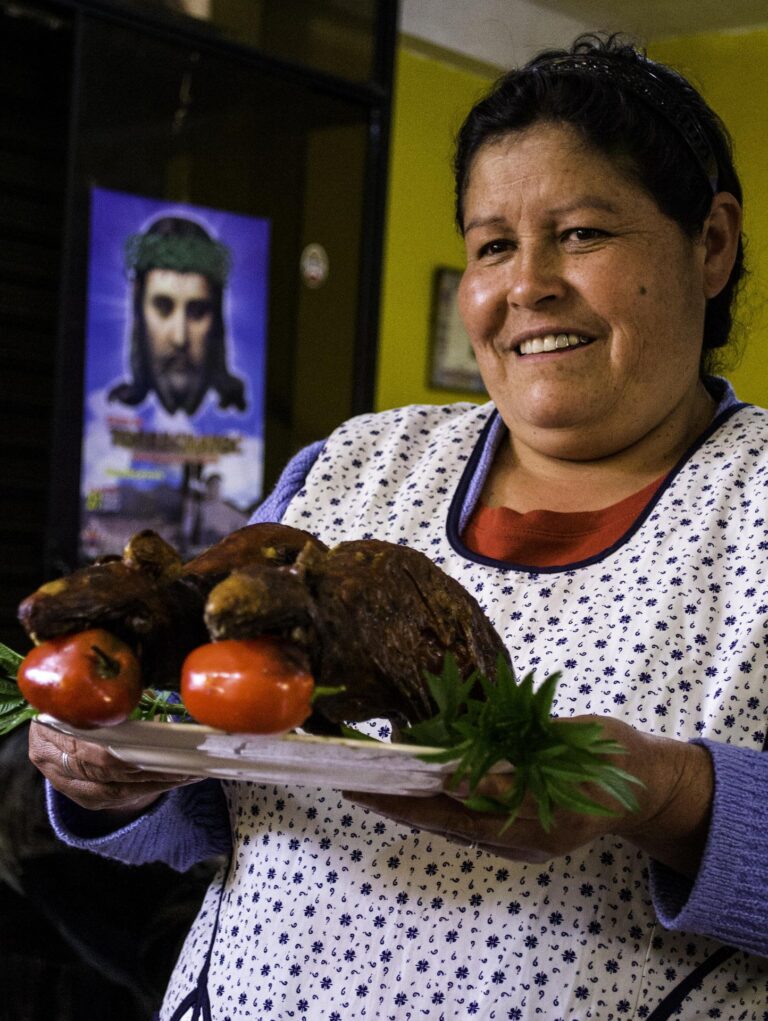 peruaanse vrouw die een bord met eten vasthoudt