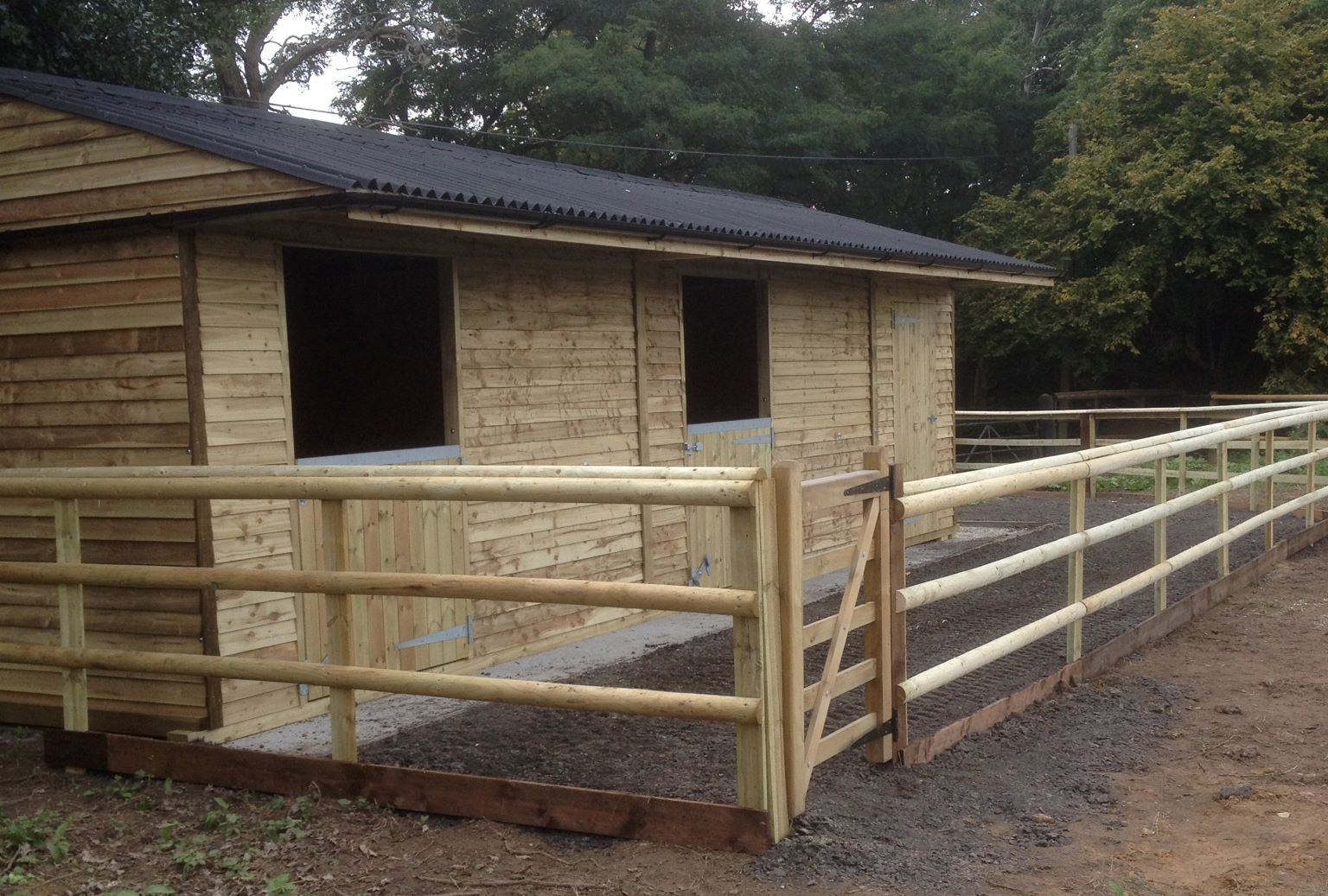 A paddock of approximately 0.38 acre enclosed by wooden fencing with a movable modern wooden stable block suitable for two horses plus a tack room.