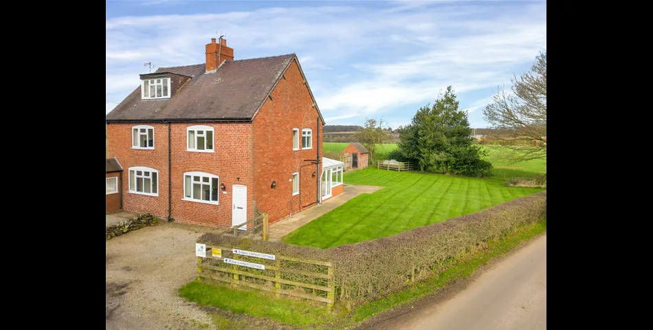 A two-bedroom semi-detached red brick cottage with generous gardens and parking