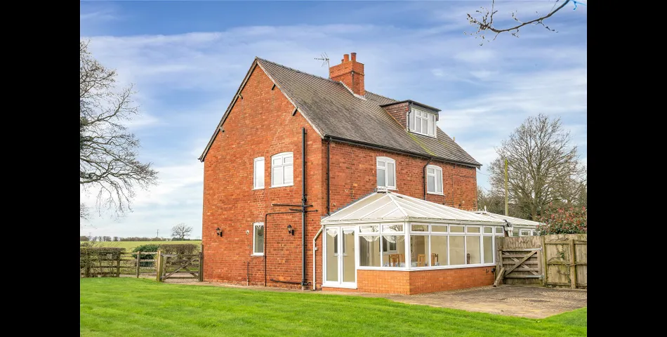A two-bedroom semi-detached red brick cottage with generous gardens and parking