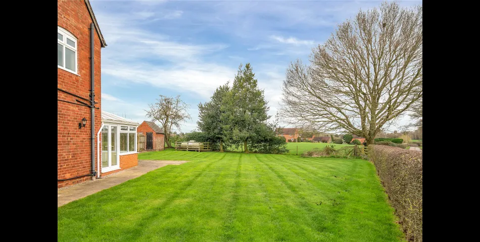 A two-bedroom semi-detached red brick cottage with generous gardens and parking