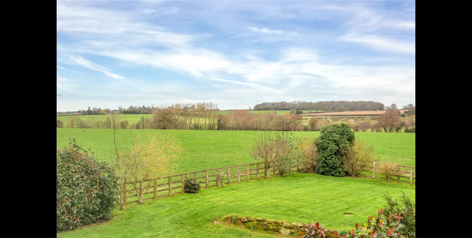 A two-bedroom semi-detached red brick cottage with generous gardens and parking