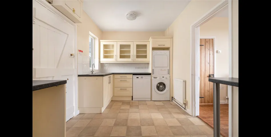 A two-bedroom semi-detached red brick cottage with generous gardens and parking