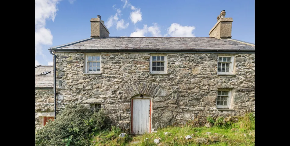 A traditional Welsh stone farmhouse requiring renovation, along with ancillary buildings, in an elevated setting with spectacular views towards Cardigan Bay and Snowdonia National Park, within 3.29 acres