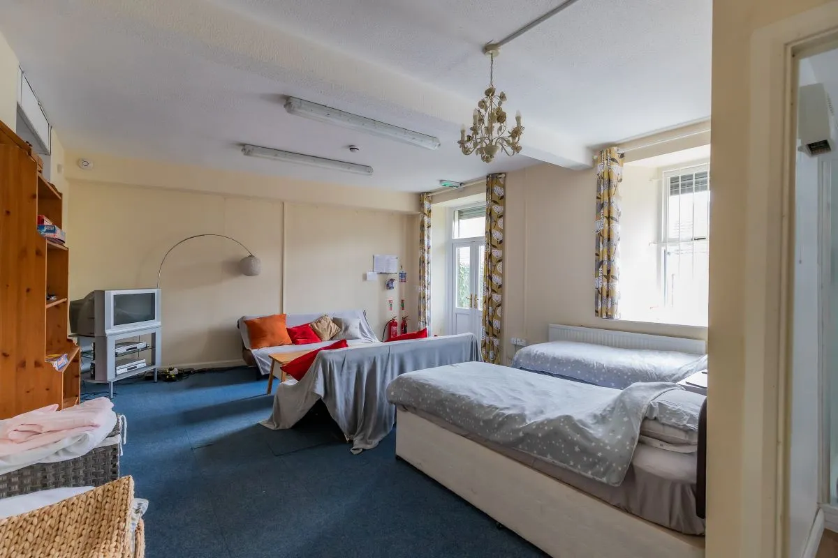 Converted chapel and further large outbuilding currently operated as a 14-16 bed short-term let/hostel with shared rooms and four bathrooms. Potential for development, subject to consents.