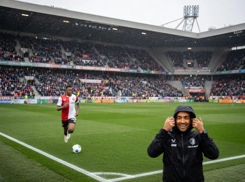 Giovanni van Bronckhorst staat langs het veld in De Kuip terwijl een Feyenoord-speler traint