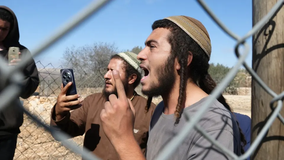 Palestijnen bij een hek in Turmus Ayya op de Westelijke Jordaanoever