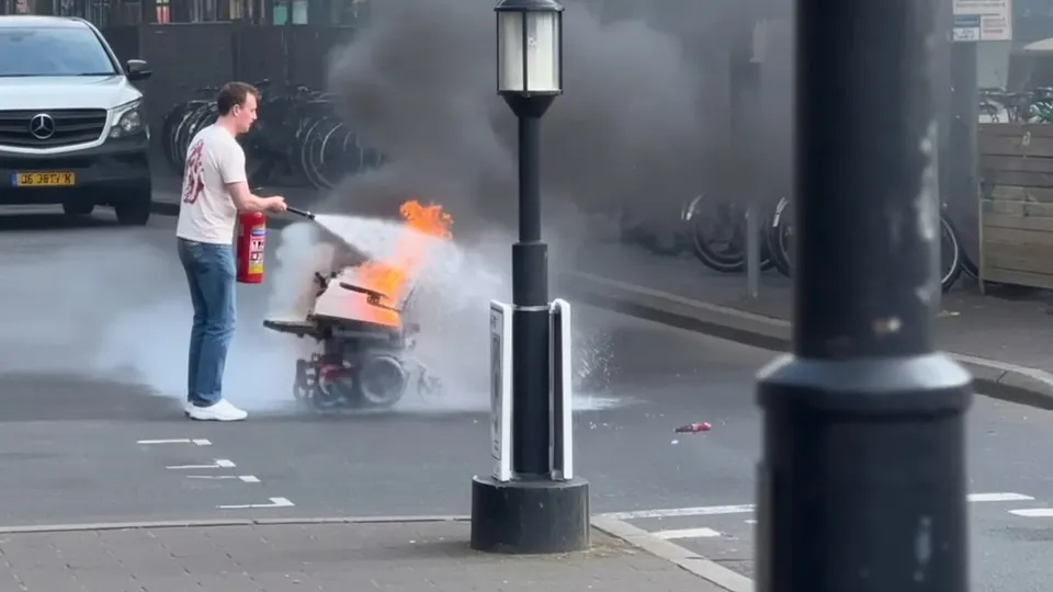 Man blust een brandende elektrische rolstoel op het Smaragdplein in Utrecht