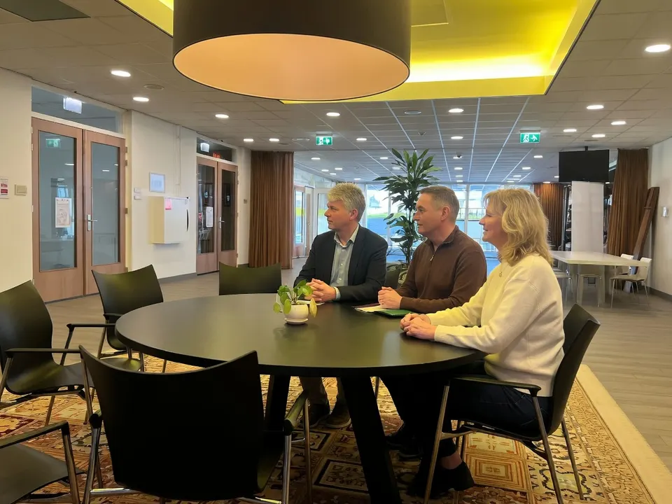 Tamar en Chaya zitten met twee andere studenten aan tafel in woonzorgcentrum De Gabrielflat