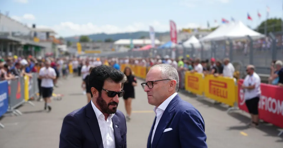 Formule 1-topman Stefano Domenicali praat met een man tijdens een autosportevenement