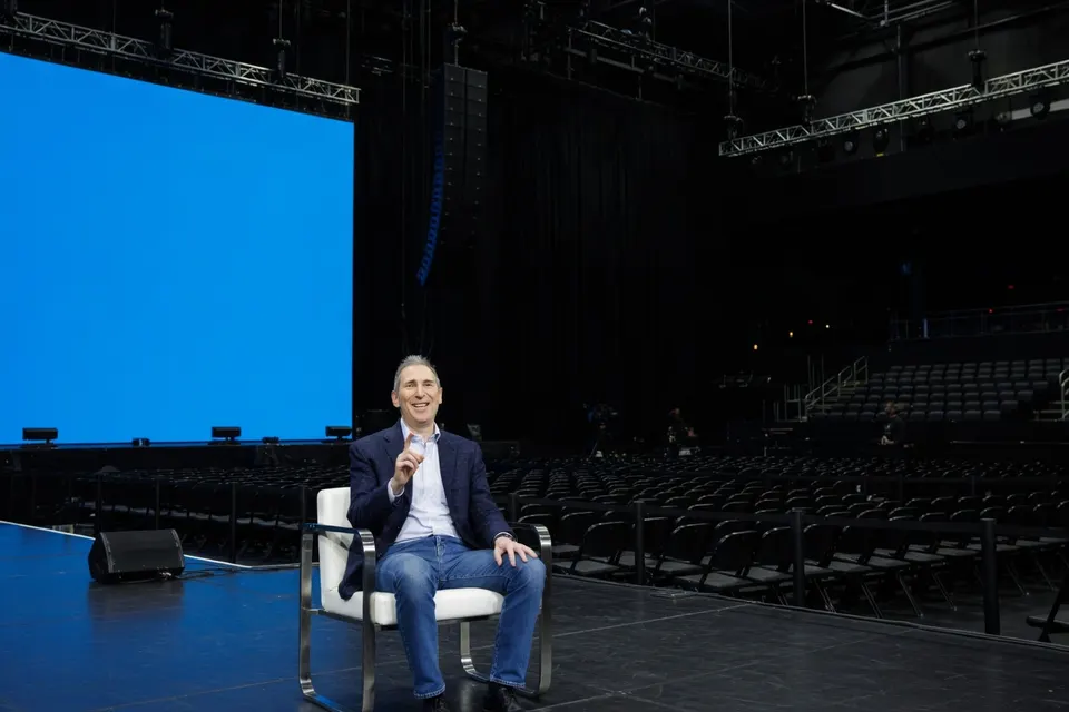 Amazon-topman Andy Jassy zit op een podium in een lege concertzaal