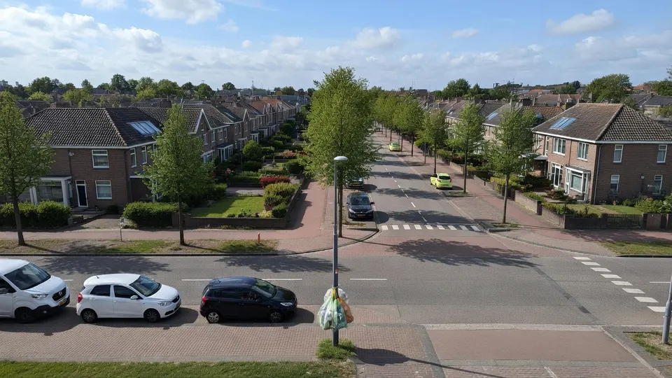 Straatbeeld in Helmond met kroonringen voor PMD-zakken langs de weg