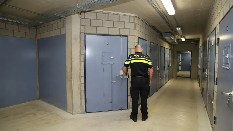 Politieagent loopt door een gang in een cellencomplex