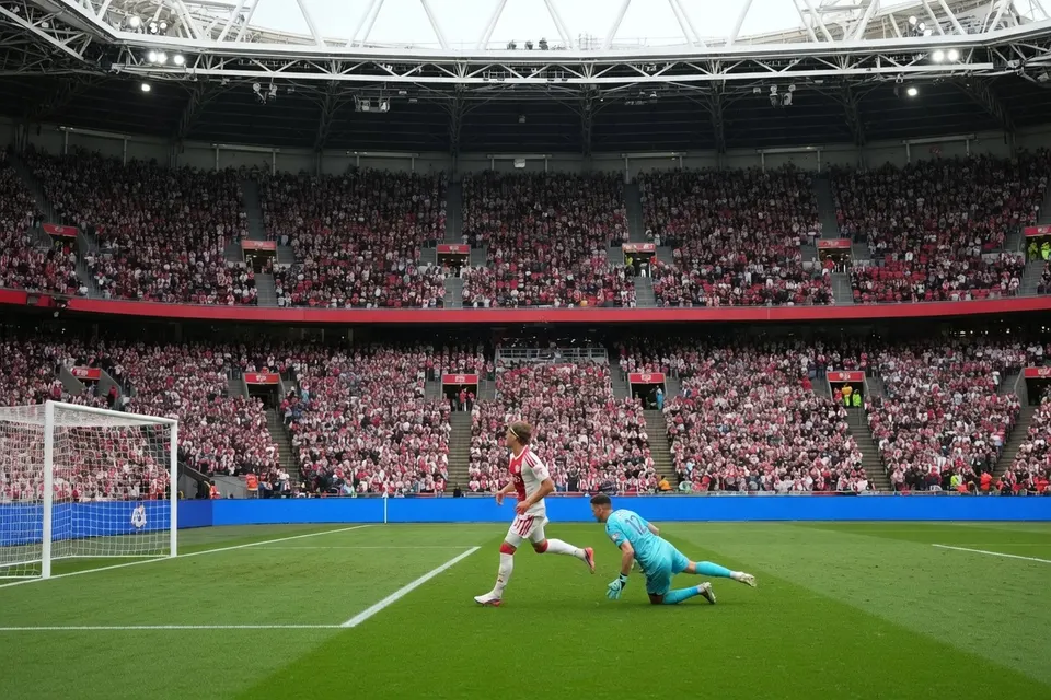 Een speler van Ajax scoort tijdens een wedstrijd