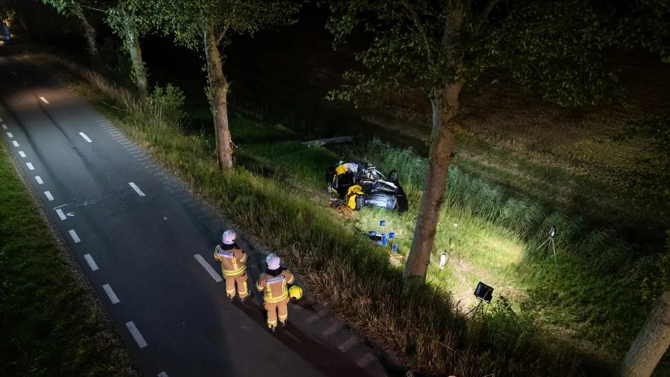 Hulpverleners bij een auto die na een eenzijdig ongeval in Dirksland naast de weg ligt