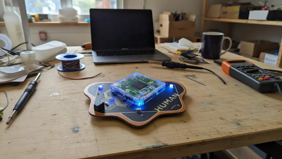 Een Defconbadge met de uitneembare beveiligingsmodule op een werkbank