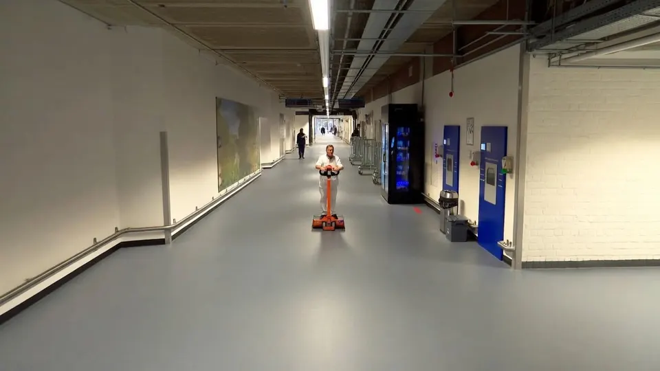 Medewerker rijdt met een schoonmaakmachine door de keldergangen van het Catharina Ziekenhuis