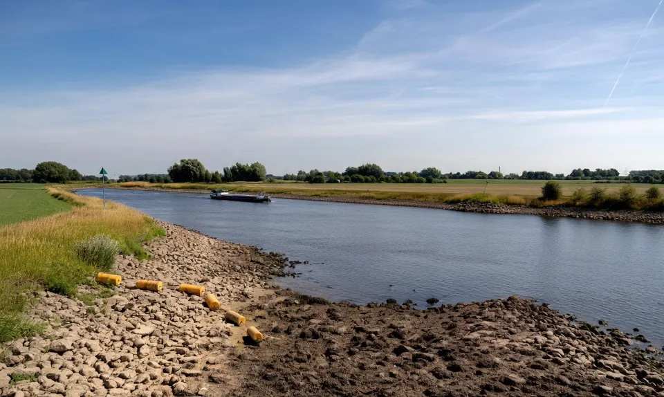 Een schip vaart over een rivier tijdens de extreme droogte