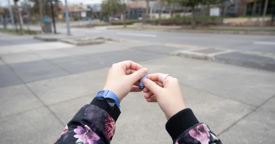 Persoon met een Fitbit om de pols tijdens een wandeling