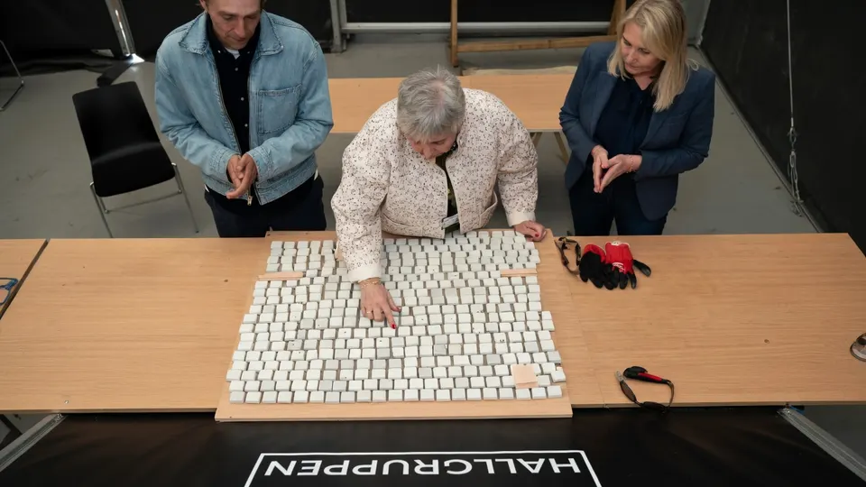 Bezoekers leggen de laatste mozaïekstenen in het monument voor de 77 slachtoffers van de aanslagen