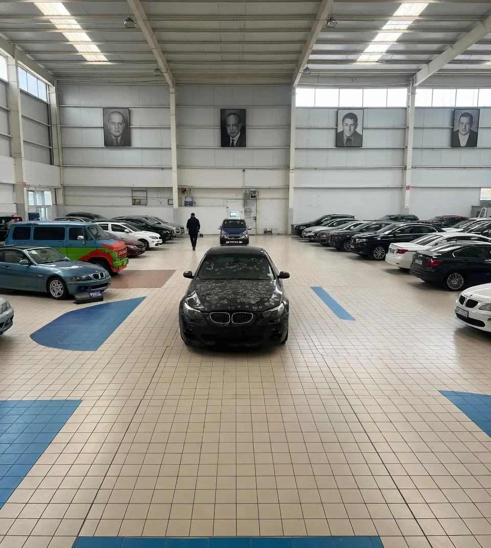 De BMW 550i met voor de film aangebrachte kogelgaten staat te koop in een showroom