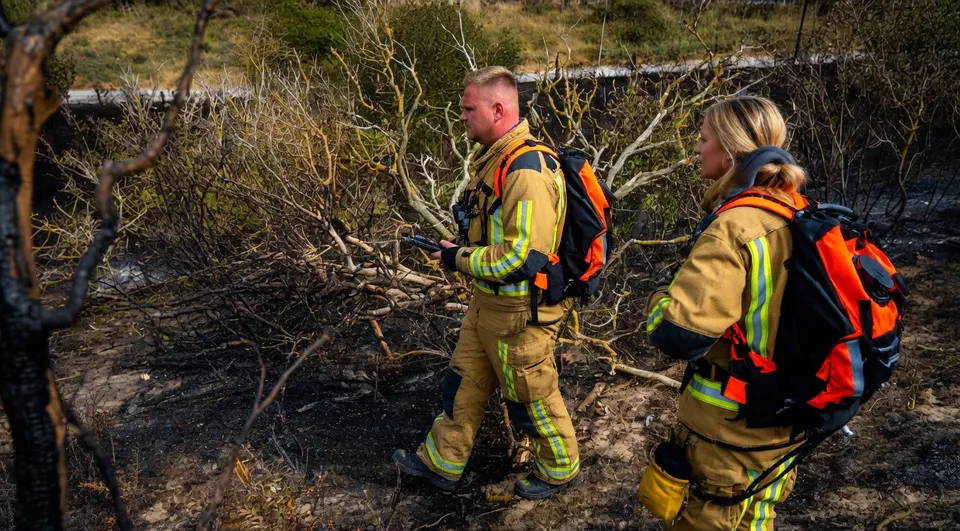 Brandweerlieden bestrijden een natuurbrand in de duinen bij Ouddorp