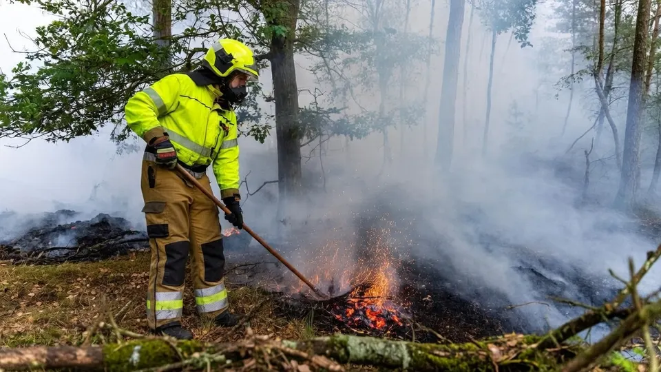 Brandweerman bestrijdt een natuurbrand in Herperduin bij Oss