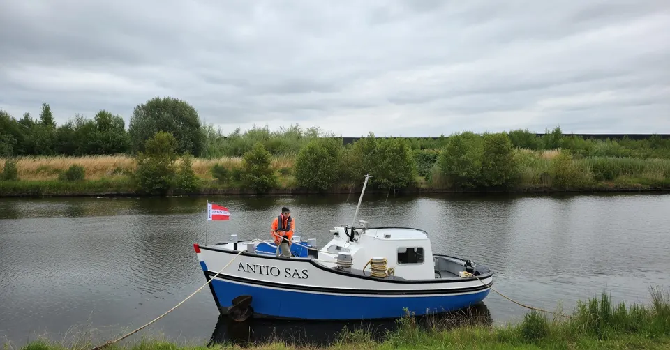 Binnenvaartschip ANTIO SAS ligt afgemeerd aan de oever