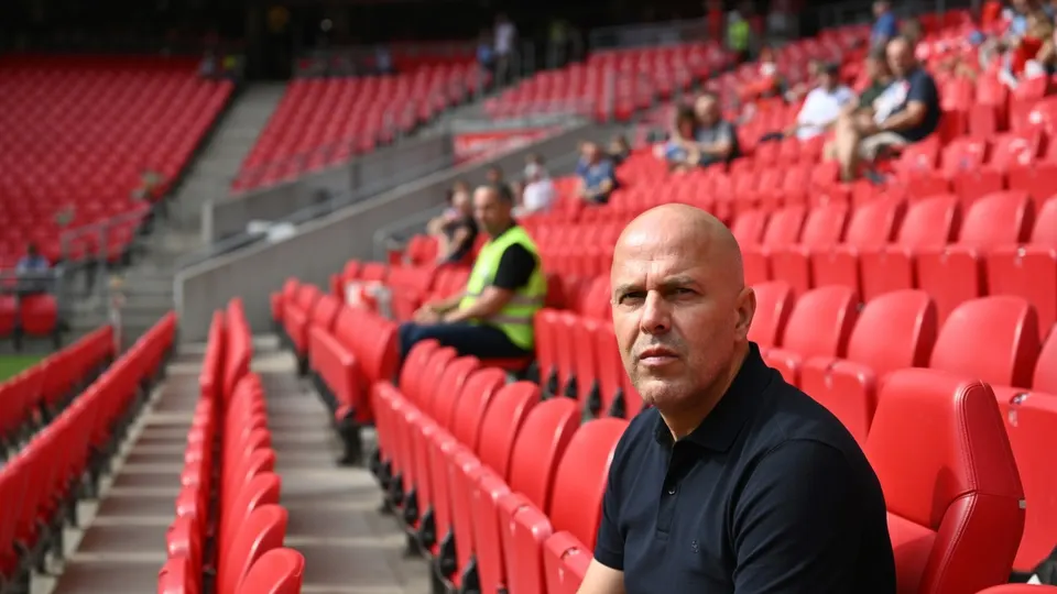 Arne Slot zit op de tribune van een voetbalstadion