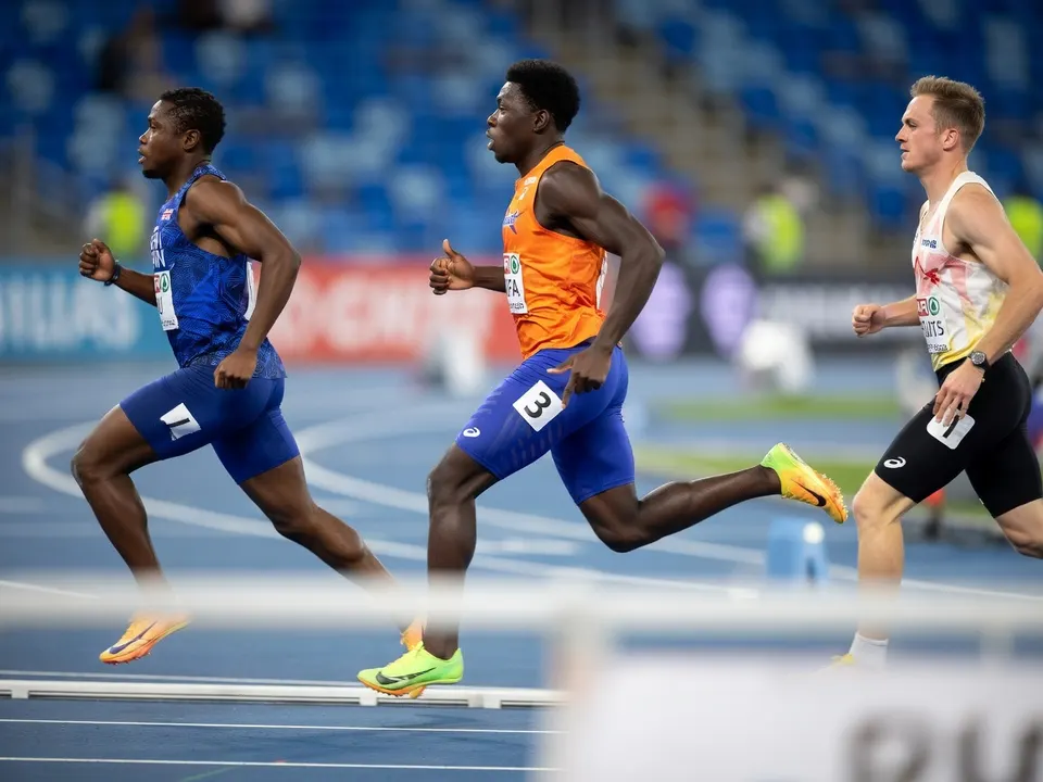 Elvis Afrifa (midden) loopt tijdens de EK-finale van de 100 meter, met Owen Ansah rechts
