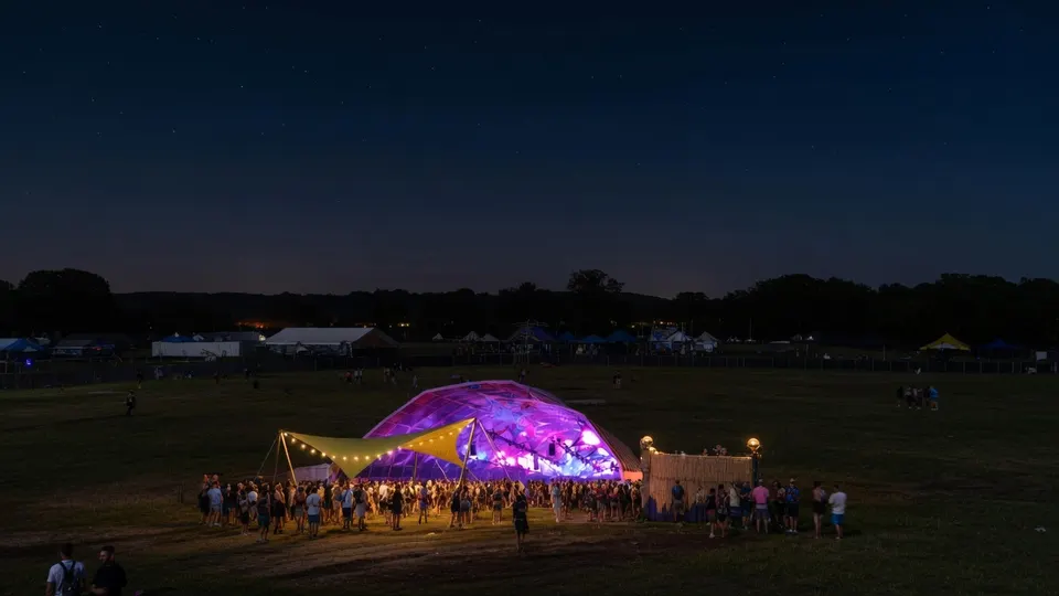 Bezoekers verzamelen zich bij een verlicht podium op het terrein van Defqon.1