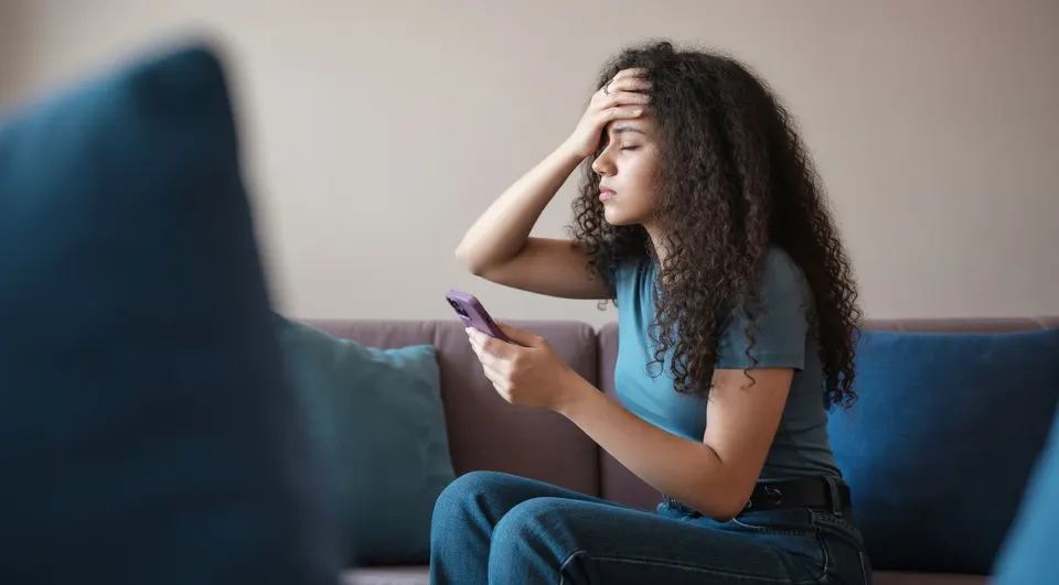 Tiener gebruikt een smartphone op de bank