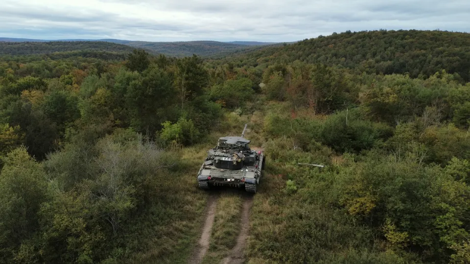 Russische tank rijdt door bebost gebied tijdens de oorlog in Oekraïne
