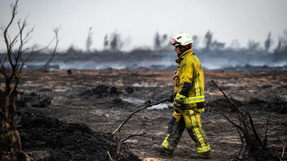 Brandweerman loopt door het afgebrande gebied in de Belgische Hoge Venen