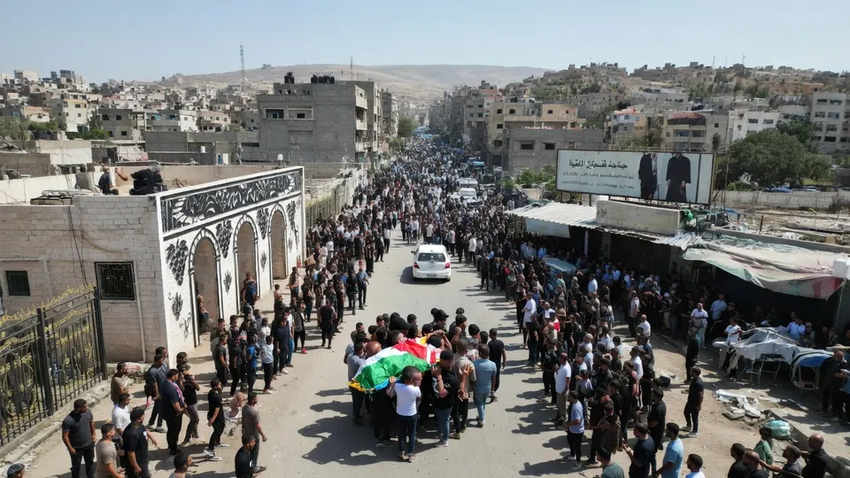 Rouwenden dragen in Sa'ir het lichaam van de 17-jarige Palestijnse jongen die werd doodgeschoten